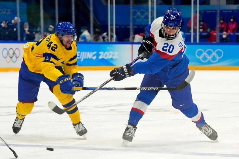 Feb 19, 2022; Beijing, China; Team Slovakia forward Juraj Slafkovsky (20) shoots the puck against Team Sweden forward Joakim Nordstrom (42) during the first period in the bronze medal men s ice hockey game during the Beijing 2022 Olympic Winter Games at National Indoor Stadium. Mandatory Credit: George Walker IV-USA TODAY Sports