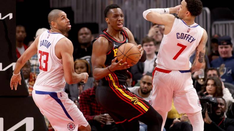 Mar 11, 2022; Atlanta, Georgia, USA; Atlanta Hawks forward Onyeka Okongwu (17) grabs a rebound against LA Clippers forward Nicolas Batum (33) and guard Amir Coffey (7) during the second half at State Farm Arena. Mandatory Credit: Jason Getz-USA TODAY Sports