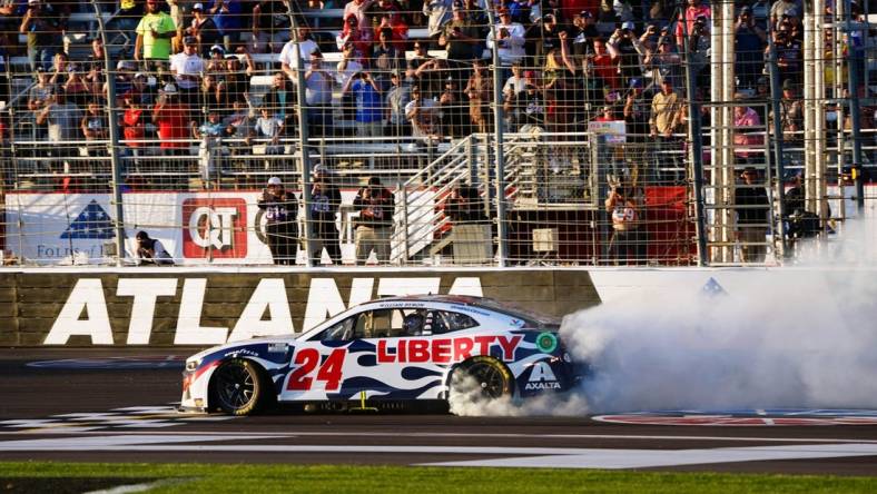 Mar 20, 2022; Hampton, Georgia, USA; NASCAR Cup Series driver William Byron (24) performs a burnout as he celebrates winning the Folds of Honor QuikTrip 500 at Atlanta Motor Speedway. Mandatory Credit: John David Mercer-USA TODAY Sports