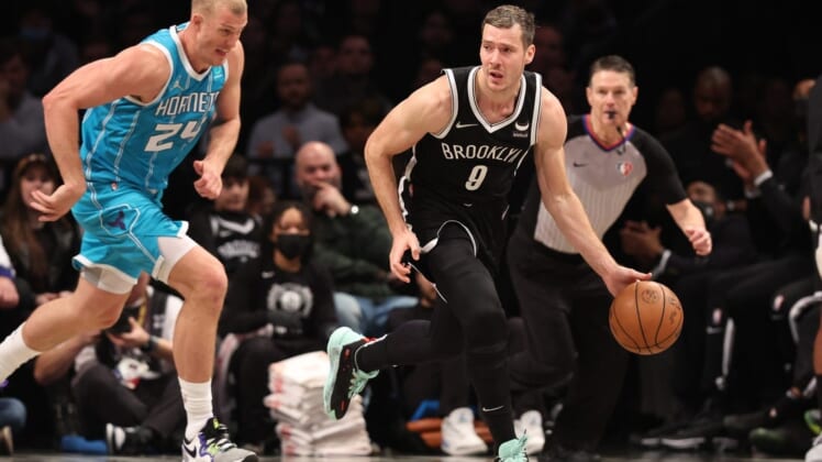 Mar 27, 2022; Brooklyn, New York, USA; Brooklyn Nets guard Goran Dragic (9) dribbles up court in front of Charlotte Hornets center Mason Plumlee (24) during the second half at Barclays Center. Mandatory Credit: Vincent Carchietta-USA TODAY Sports
