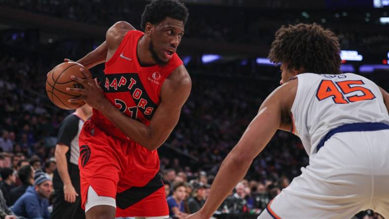 Apr 10, 2022; New York, New York, USA; Toronto Raptors forward Thaddeus Young (21) shields the ball from New York Knicks forward Jericho Sims (45) during the first half at Madison Square Garden. Mandatory Credit: Vincent Carchietta-USA TODAY Sports