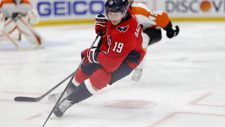 Apr 12, 2022; Washington, District of Columbia, USA; Washington Capitals center Nicklas Backstrom (19) skates with the puck as Philadelphia Flyers left wing Noah Cates (49) chases in the third period in the third period at Capital One Arena. Mandatory Credit: Geoff Burke-USA TODAY Sports