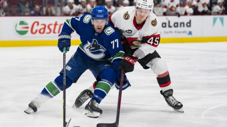 Apr 19, 2022; Vancouver, British Columbia, CAN; Vancouver Canucks defenseman Brad Hunt (77) battles with Ottawa Senators forward Parker Kelly (45) in the second period at Rogers Arena. Mandatory Credit: Bob Frid-USA TODAY Sports