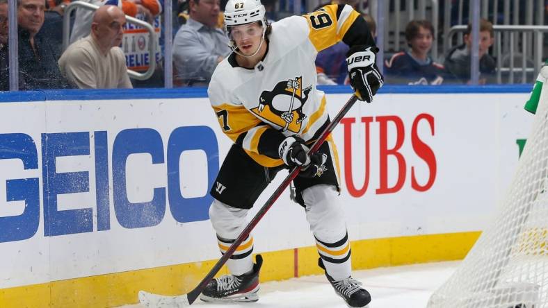 Apr 12, 2022; Elmont, New York, USA; Pittsburgh Penguins right wing Rickard Rakell (67) controls the puck against the New York Islanders during the first period at UBS Arena. Mandatory Credit: Tom Horak-USA TODAY Sports