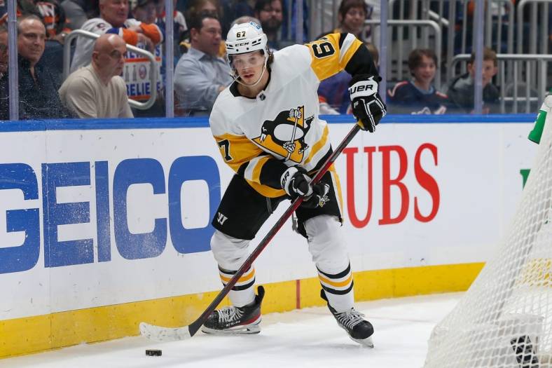 Apr 12, 2022; Elmont, New York, USA; Pittsburgh Penguins right wing Rickard Rakell (67) controls the puck against the New York Islanders during the first period at UBS Arena. Mandatory Credit: Tom Horak-USA TODAY Sports