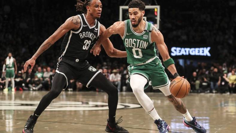 Apr 23, 2022; Brooklyn, New York, USA;  Boston Celtics forward Jayson Tatum (0) drives past Brooklyn Nets forward Nic Claxton (33) in the first quarter at Barclays Center. Mandatory Credit: Wendell Cruz-USA TODAY Sports