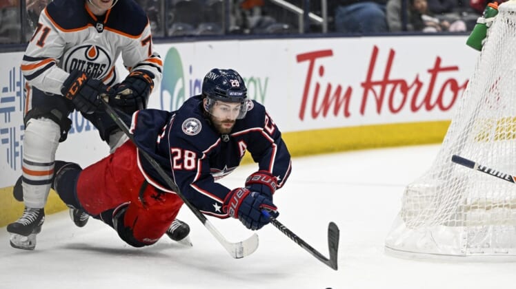 Apr 24, 2022; Columbus, Ohio, USA; Columbus Blue Jackets right wing Oliver Bjorkstrand (28) is knocked down by Edmonton Oilers center Ryan McLeod (71) in the third period at Nationwide Arena. Mandatory Credit: Gaelen Morse-USA TODAY Sports