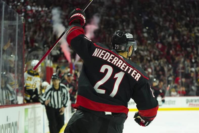 May 4, 2022; Raleigh, North Carolina, USA; Carolina Hurricanes right wing Nino Niederreiter (21) celebrates an empty net goal against Boston Bruins during the third period in game two of the first round of the 2022 Stanley Cup Playoffs at PNC Arena. Mandatory Credit: James Guillory-USA TODAY Sports