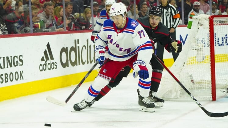 May 30, 2022; Raleigh, North Carolina, USA; New York Rangers center Frank Vatrano (77) controls the puck past Carolina Hurricanes defenseman Brady Skjei (76) during the second period in game seven of the second round of the 2022 Stanley Cup Playoffs at PNC Arena. Mandatory Credit: James Guillory-USA TODAY Sports