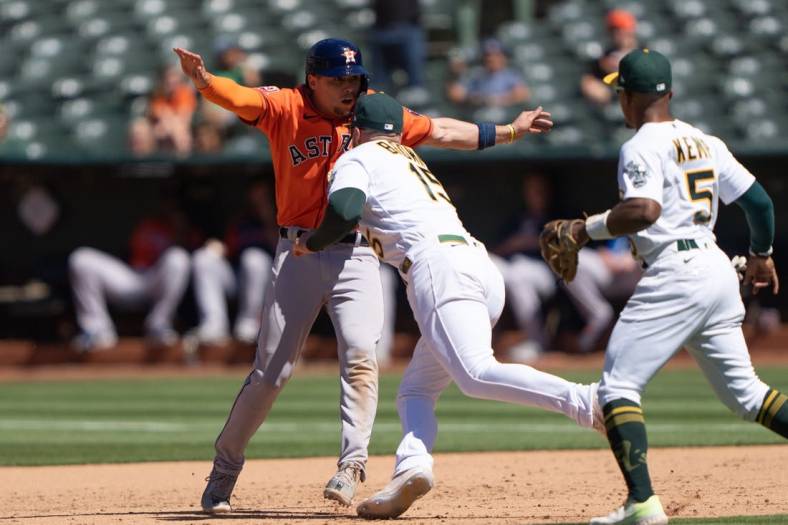 Jun 1, 2022; Oakland, California, USA;  Houston Astros second baseman Aledmys Diaz (16) gets tagged out by Oakland Athletics left fielder Seth Brown (15) during the ninth inning at RingCentral Coliseum. Mandatory Credit: Stan Szeto-USA TODAY Sports