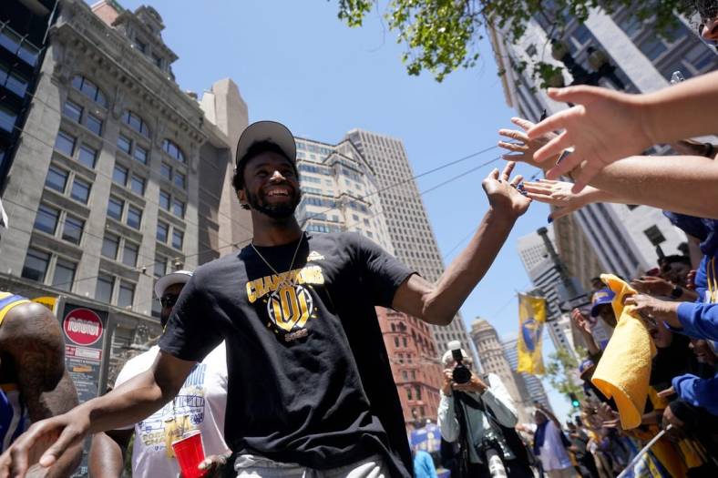 Jun 20, 2022; San Francisco, CA, USA; Golden State Warriors forward Andrew Wiggins gives high fives to fans during the Warriors championship parade in downtown San Francisco. Mandatory Credit: Cary Edmondson-USA TODAY Sports