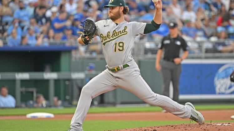 Jun 24, 2022; Kansas City, Missouri, USA; Oakland Athletics starting pitcher Cole Irvin (19) delivers a pitch during the first inning against the Kansas City Royals at Kauffman Stadium. Mandatory Credit: Peter Aiken-USA TODAY Sports