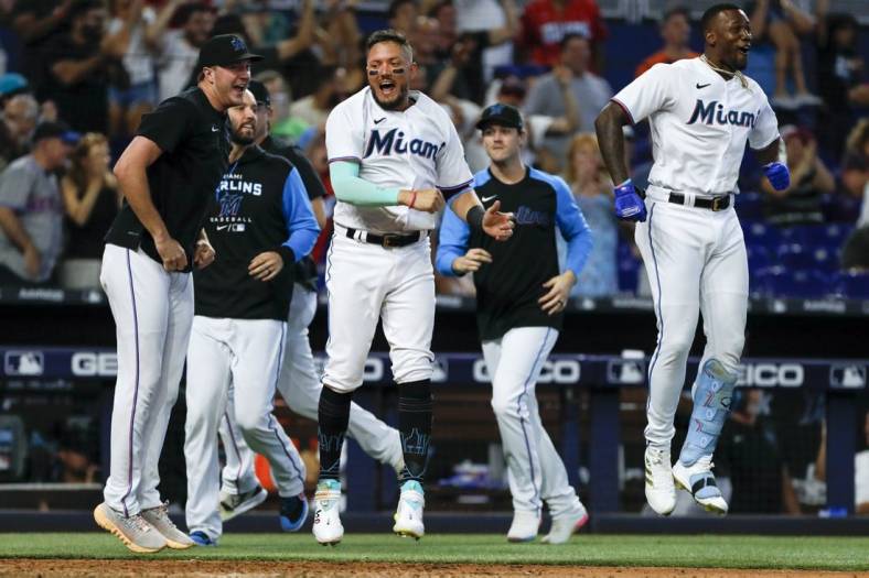 Jun 26, 2022; Miami, Florida, USA; Miami Marlins shortstop Miguel Rojas (11) reacts after a walk-off home run from catcher Nick Fortes (not pictured) in the ninth inning against the New York Mets at loanDepot Park. Mandatory Credit: Sam Navarro-USA TODAY Sports