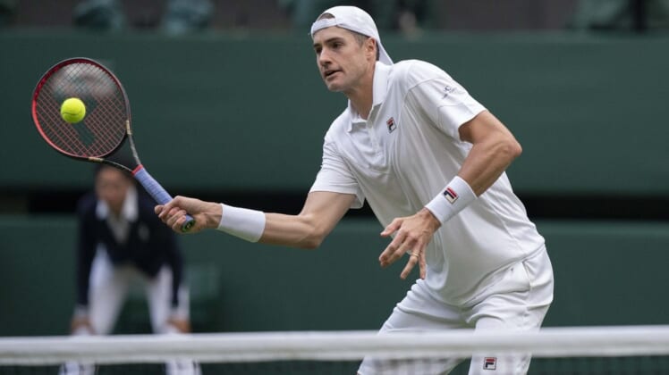 Jun 29, 2022; London, United Kingdom; John Isner (USA) returns a shot during his second round match against Andy Murray (GBR) on day three at All England Lawn Tennis and Croquet Club. Mandatory Credit: Susan Mullane-USA TODAY Sports