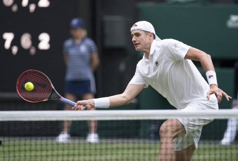 Jun 29, 2022; London, United Kingdom; John Isner (USA) returns a shot during his second round match against Andy Murray (GBR) on day three at All England Lawn Tennis and Croquet Club. Mandatory Credit: Susan Mullane-USA TODAY Sports