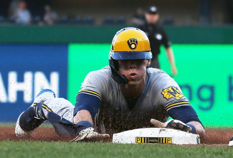 Jun 30, 2022; Pittsburgh, Pennsylvania, USA; Milwaukee Brewers left fielder Christian Yelich (22) slides safely into third base with an RBI triple against the Pittsburgh Pirates during the third inning at PNC Park. Mandatory Credit: Charles LeClaire-USA TODAY Sports