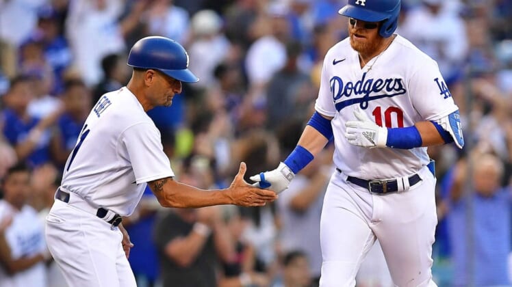Jun 30, 2022; Los Angeles, California, USA; Los Angeles Dodgers third baseman Justin Turner (10) is greeted by third base coach Dino Ebel (91) after hitting a solo home run against the San Diego Padres during the second inning at Dodger Stadium. Mandatory Credit: Gary A. Vasquez-USA TODAY Sports