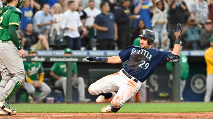 Jun 30, 2022; Seattle, Washington, USA; Seattle Mariners catcher Cal Raleigh (29) scores a run on an error after hitting a two-RBI triple against the Oakland Athletics during the fifth inning at T-Mobile Park. Mandatory Credit: Steven Bisig-USA TODAY Sports