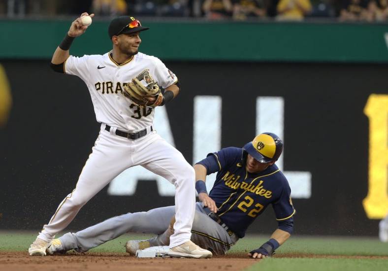 Jul 1, 2022; Pittsburgh, Pennsylvania, USA;  Pittsburgh Pirates second baseman Tucupita Marcano (30) throws to first base after a force out of Milwaukee Brewers left fielder Christian Yelich (22) at second base during the second inning at PNC Park. Mandatory Credit: Charles LeClaire-USA TODAY Sports