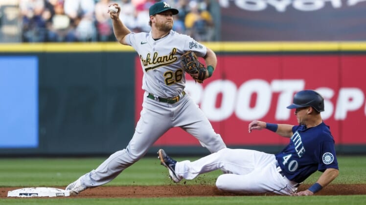 Jul 1, 2022; Seattle, Washington, USA; Oakland Athletics third baseman Sheldon Neuse (26) attempts to turn a double play against Seattle Mariners catcher Andrew Knapp (40) during the third inning at T-Mobile Park. The runner was safe at first. Mandatory Credit: Joe Nicholson-USA TODAY Sports
