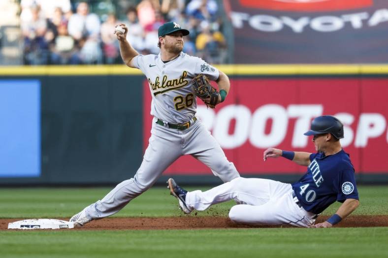 Jul 1, 2022; Seattle, Washington, USA; Oakland Athletics third baseman Sheldon Neuse (26) attempts to turn a double play against Seattle Mariners catcher Andrew Knapp (40) during the third inning at T-Mobile Park. The runner was safe at first. Mandatory Credit: Joe Nicholson-USA TODAY Sports