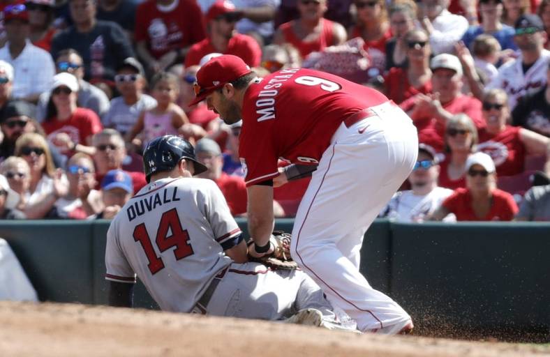 Jul 2, 2022; Cincinnati, Ohio, USA; Atlanta Braves left fielder Adam Duvall (14) is picked-off at first by Cincinnati Reds first baseman Mike Moustakas (9) during the second inning at Great American Ball Park. Mandatory Credit: David Kohl-USA TODAY Sports