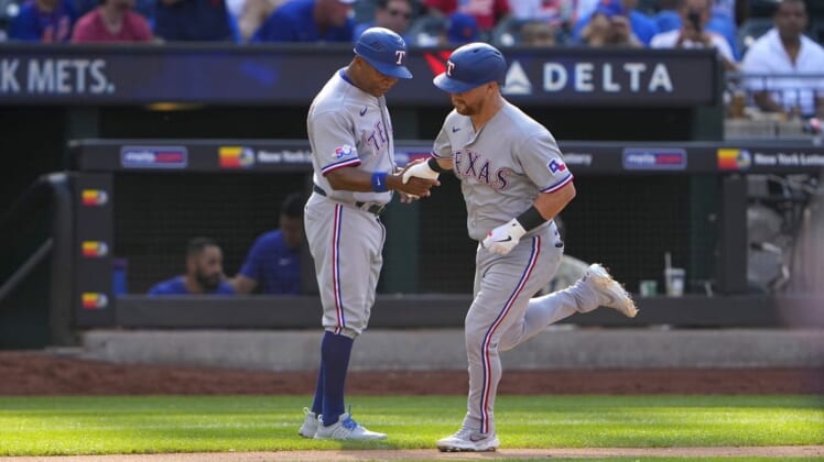 Jul 2, 2022; New York City, New York, USA;  Texas Rangers right fielder Kole Calhoun (56) is congratulated by third base coach Tony Beasley (27) as he rounds the bases after hitting a home run during the fourth inning at Citi Field. Mandatory Credit: Gregory Fisher-USA TODAY Sports