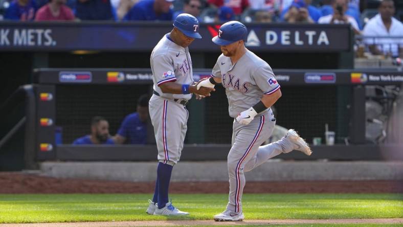 Jul 2, 2022; New York City, New York, USA;  Texas Rangers right fielder Kole Calhoun (56) is congratulated by third base coach Tony Beasley (27) as he rounds the bases after hitting a home run during the fourth inning at Citi Field. Mandatory Credit: Gregory Fisher-USA TODAY Sports