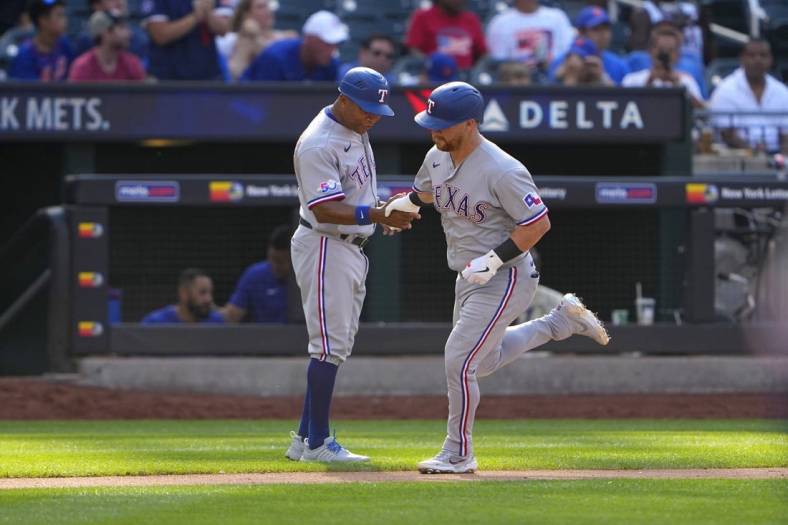 Jul 2, 2022; New York City, New York, USA;  Texas Rangers right fielder Kole Calhoun (56) is congratulated by third base coach Tony Beasley (27) as he rounds the bases after hitting a home run during the fourth inning at Citi Field. Mandatory Credit: Gregory Fisher-USA TODAY Sports