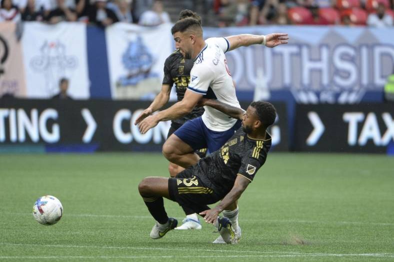 Jul 2, 2022; Vancouver, British Columbia, CAN;  Los Angeles FC midfielder Kellyn Acosta (23) collides with Vancouver Whitecaps forward Lucas Cavallini (9) during the first half at BC Place. Mandatory Credit: Anne-Marie Sorvin-USA TODAY Sports