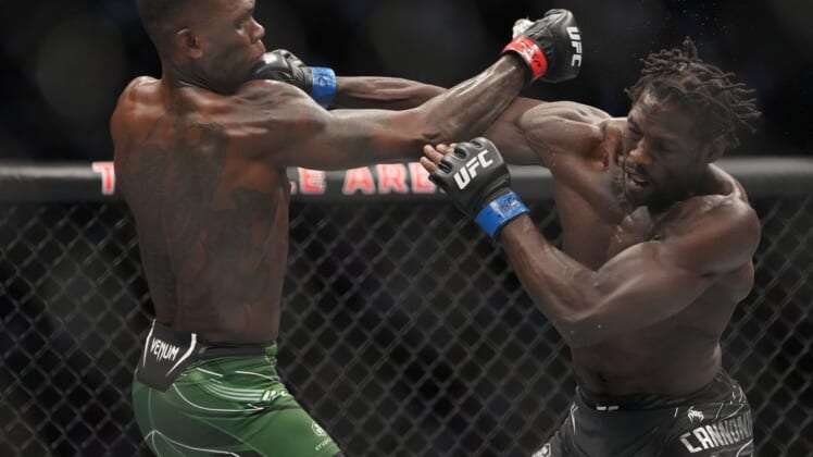 Jul 2, 2022; Las Vegas, Nevada, USA; Israel Adesanya (red gloves) and Jared Cannonier (blue gloves) fight in a bout during UFC 276 at T-Mobile Arena. Mandatory Credit: Stephen R. Sylvanie-USA TODAY Sports