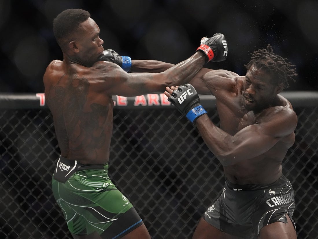 Jul 2, 2022; Las Vegas, Nevada, USA; Israel Adesanya (red gloves) and Jared Cannonier (blue gloves) fight in a bout during UFC 276 at T-Mobile Arena. Mandatory Credit: Stephen R. Sylvanie-USA TODAY Sports