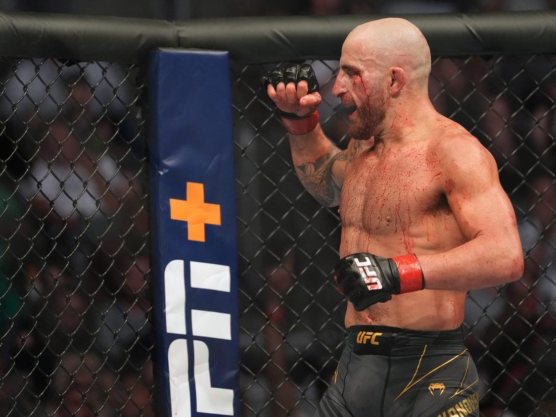 Jul 2, 2022; Las Vegas, Nevada, USA; (Editor s Note: Graphic Content) Alexander Volkanovski (red gloves) reacts after defeating Max Holloway (blue gloves) during UFC 276 at T-Mobile Arena. Mandatory Credit: Stephen R. Sylvanie-USA TODAY Sports