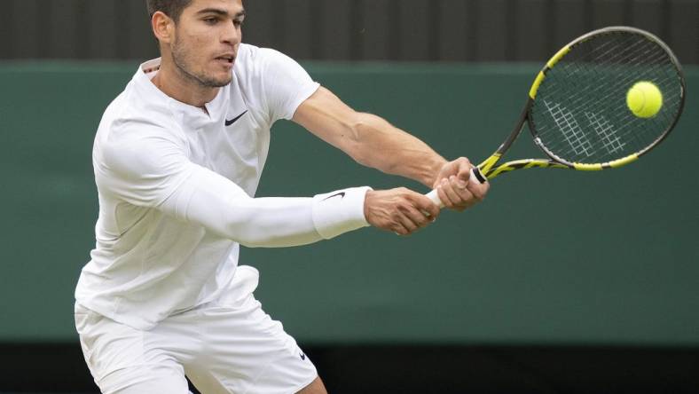 Jul 3, 2022; London, United Kingdom; Carlos Alcaraz (ESP) returns a shot during his match against Jannik Sinner (ITA) on day seven at All England Lawn Tennis and Croquet Club. Mandatory Credit: Susan Mullane-USA TODAY Sports