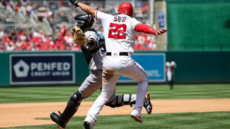 Jul 3, 2022; Washington, District of Columbia, USA; Washington Nationals right fielder Juan Soto (22) is called out after attempting to avoid the tag of Miami Marlins catcher Jacob Stallings (58) during the fourth inning at Nationals Park. Mandatory Credit: Scott Taetsch-USA TODAY Sports
