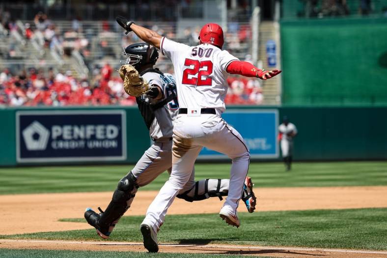 Jul 3, 2022; Washington, District of Columbia, USA; Washington Nationals right fielder Juan Soto (22) is called out after attempting to avoid the tag of Miami Marlins catcher Jacob Stallings (58) during the fourth inning at Nationals Park. Mandatory Credit: Scott Taetsch-USA TODAY Sports