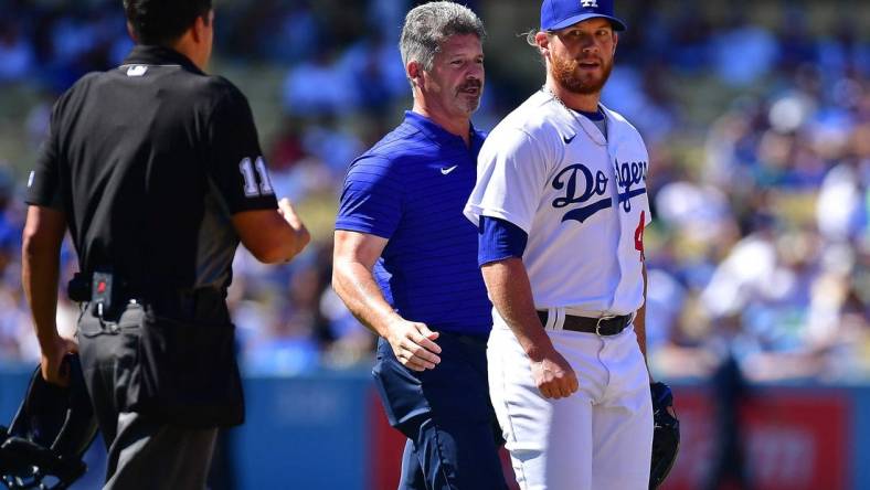 Jul 3, 2022; Los Angeles, California, USA; Los Angeles Dodgers relief pitcher Craig Kimbrel (46) with trainer Nate Lucero after taking a comeback hit by San Diego Padres second baseman Jake Cronenworth (9) during the ninth inning at Dodger Stadium. Mandatory Credit: Gary A. Vasquez-USA TODAY Sports