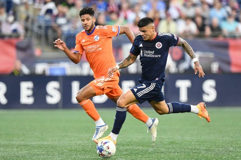 Jul 3, 2022; Foxborough, Massachusetts, USA; New England Revolution forward Gustavo Bou (7) controls the ball in front of FC Cincinnati defender Ian Murphy (32) during the first half at Gillette Stadium. Mandatory Credit: Brian Fluharty-USA TODAY Sports