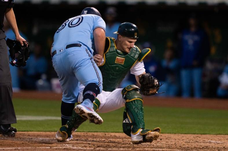Jul 5, 2022; Oakland, California, USA; Toronto Blue Jays catcher Alejandro Kirk (30) collides with Oakland Athletics catcher Sean Murphy (12) during the sixth inning at RingCentral Coliseum. Mandatory Credit: Stan Szeto-USA TODAY Sports