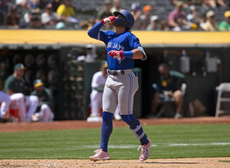 Jul 6, 2022; Oakland, California, USA; Toronto Blue Jays shortstop Bo Bichette (11) celebrates after hitting a solo home run against the Oakland Athletics during the eighth inning at RingCentral Coliseum. Mandatory Credit: D. Ross Cameron-USA TODAY Sports
