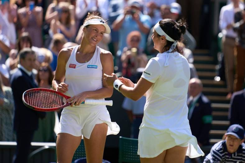 Jul 7, 2022; London, England, United Kingdom;  
Ons Jabeur (TUN), pictured right, celebrates at the net after her semi finals women s singles match against Tatjana Maria (GER) who is a close friend on Centre court at All England Lawn Tennis and Croquet Club. Mandatory Credit: Peter van den Berg-USA TODAY Sports