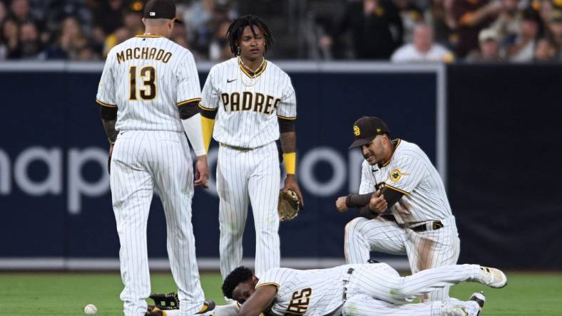 Jul 7, 2022; San Diego, California, USA; San Diego Padres shortstop baseman C.J. Abrams (top, center) and left fielder Jurickson Profar (bottom) react after colliding during the fifth inning against the San Francisco Giants at Petco Park. Mandatory Credit: Orlando Ramirez-USA TODAY Sports