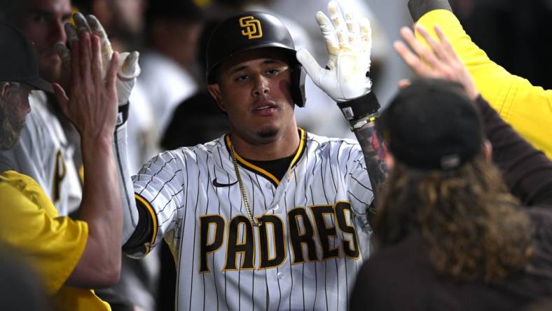 Jul 7, 2022; San Diego, California, USA; San Diego Padres third baseman Manny Machado (13) is congratulated in the dugout after hitting a home run against the San Francisco Giants during the fifth inning at Petco Park. Mandatory Credit: Orlando Ramirez-USA TODAY Sports