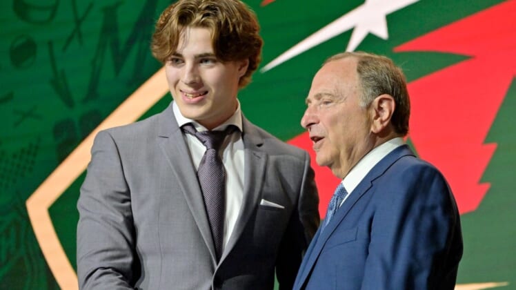 Jul 7, 2022; Montreal, Quebec, CANADA; Liam Ohgren shakes hands with NHL commissioner Gary Bettman after being selected as the number nineteen overall pick to the Minnesota Wild in the first round of the 2022 NHL Draft at Bell Centre. Mandatory Credit: Eric Bolte-USA TODAY Sports
