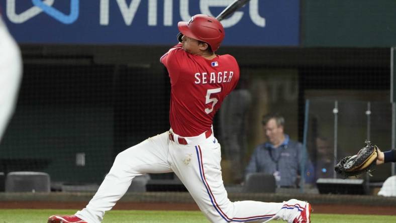 Jul 8, 2022; Arlington, Texas, USA; Texas Rangers shortstop Corey Seager (5) hits a three run home run against the Minnesota Twins during the fifth inning at Globe Life Field. Mandatory Credit: Jim Cowsert-USA TODAY Sports