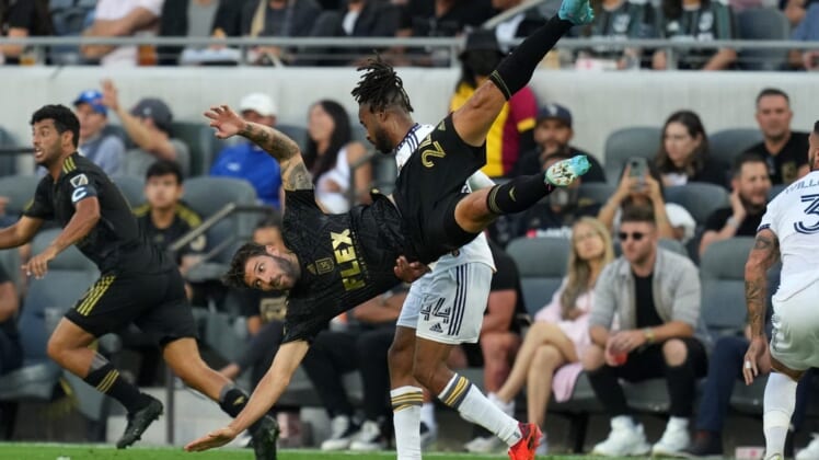 Jul 8, 2022; Los Angeles, California, USA; LAFC midfielder Ryan Hollingshead (24) is upended by LA Galaxy forward Raheem Edwards (44) in the first half at Banc of California Stadium. Mandatory Credit: Kirby Lee-USA TODAY Sports