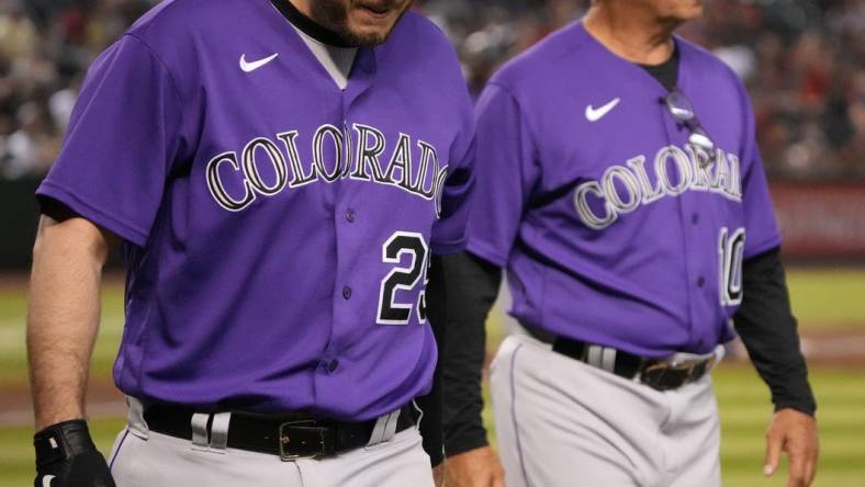 Jul 8, 2022; Phoenix, Arizona, USA; Colorado Rockies first baseman C.J. Cron (25) leaves the game alongside manager Bud Black (10) after being hit by a pitch against the Arizona Diamondbacks during the fifth inning at Chase Field. Mandatory Credit: Joe Camporeale-USA TODAY Sports