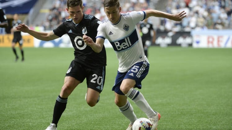 Jul 8, 2022; Vancouver, British Columbia, CAN;  Vancouver Whitecaps FC midfielder Ryan Gauld (25) controls the ball against Minnesota United FC midfielder Will Trapp (20) during the first half at BC Place. Mandatory Credit: Anne-Marie Sorvin-USA TODAY Sports