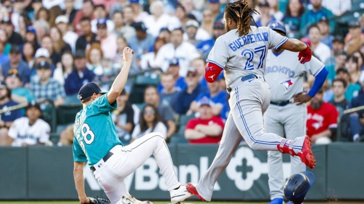 Jul 8, 2022; Seattle, Washington, USA; Seattle Mariners starting pitcher George Kirby (68) steps on first base before Toronto Blue Jays designated hitter Vladimir Guerrero Jr. (27) for a groundout during the third inning at T-Mobile Park. Mandatory Credit: Joe Nicholson-USA TODAY Sports