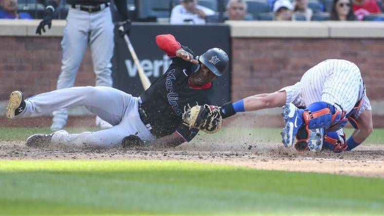 Jul 9, 2022; New York City, New York, USA;  Miami Marlins center fielder Jesus Sanchez (7) is tagged out at home by New York Mets catcher James McCann (33) in the sixth inning at Citi Field. Mandatory Credit: Wendell Cruz-USA TODAY Sports